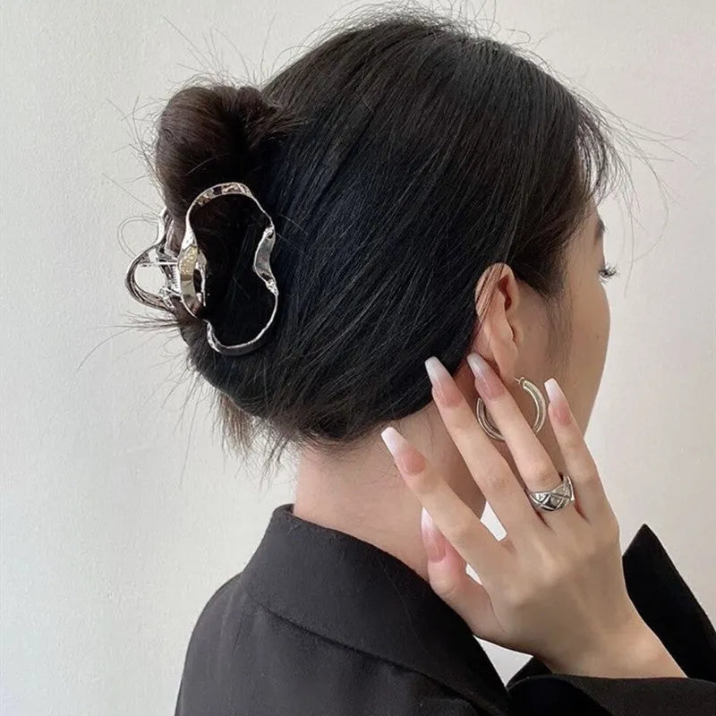 Assortment of silver metal hair barrettes and claw clips in various Korean-style designs on a white background.