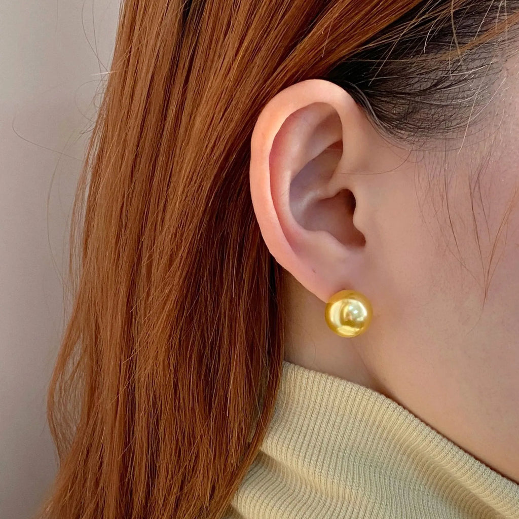 Large geometric pearl stud earrings for women in silver, showing eight-point star detail on setting.