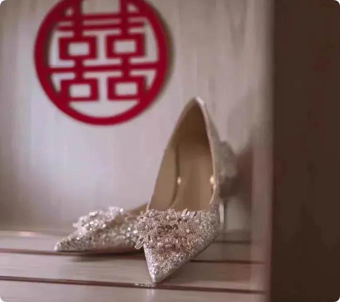 Champagne-coloured women's bridal shoes with rhinestone details, pointed toe, and a fine heel.