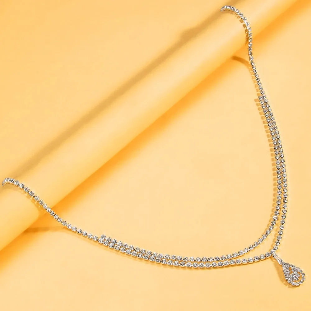 Gold or silver women's waist chain with water drop pendant and rhinestone decoration, showing lobster clasp closure.