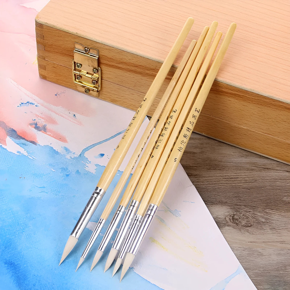 Six wooden-handled pointed pen brushes for wool and fabric crafts laid out together.