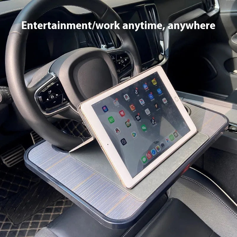 Large black car steering wheel laptop and dining tray table with foldable cup holder, shown on a steering wheel.