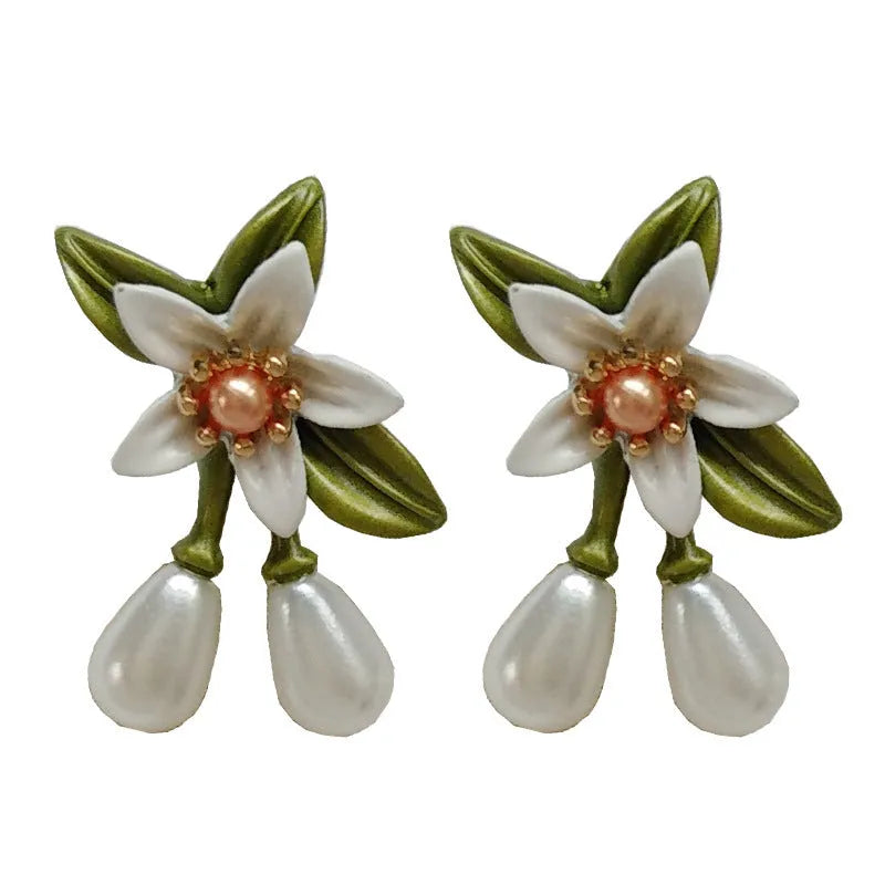 Women's alloy flower earrings with needle camellia design in sterling silver colour, shown as clip-on and ear stud styles