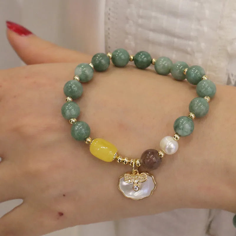 Green jade beaded bracelet with a silver-toned shell charm on an adjustable black cord.