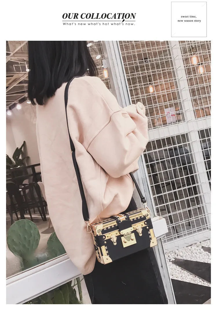 Hard structured black PU leather women's shoulder bag with decorative rivets and single adjustable strap