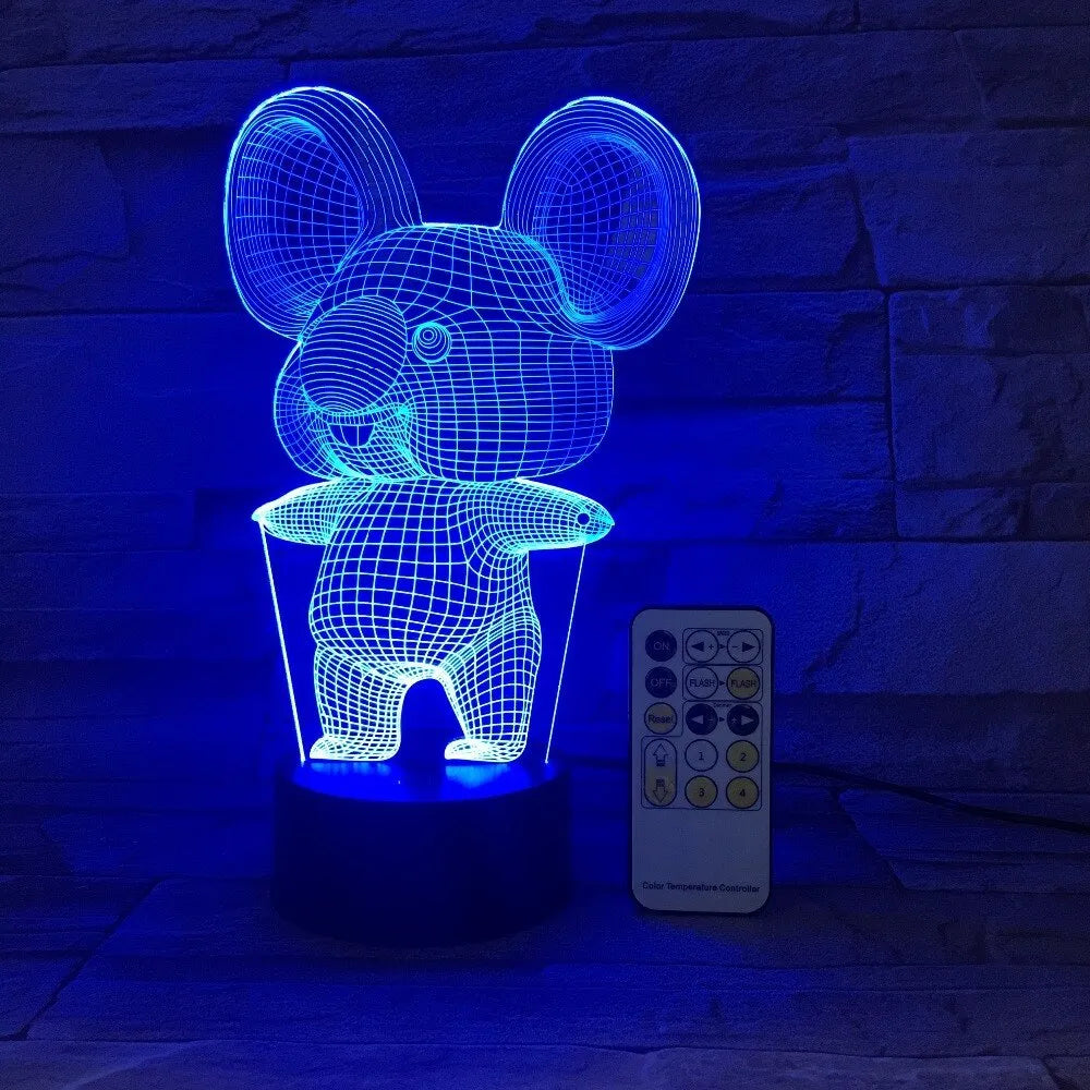 Black koala night light with colourful LED glow on a small table, showing remote control.