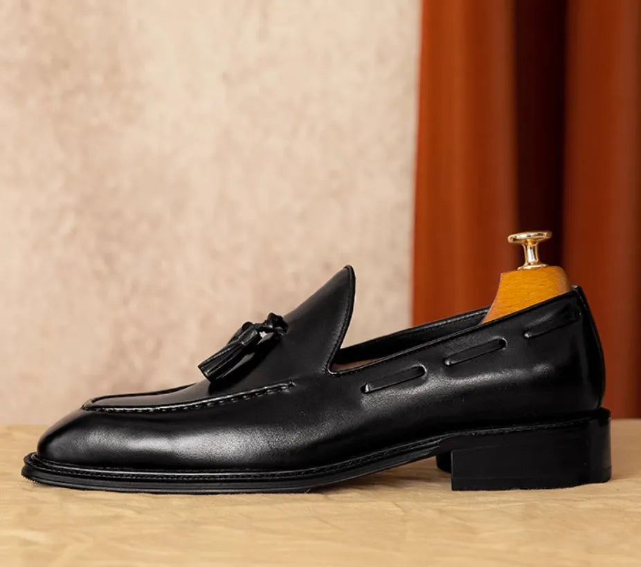 Men's black genuine leather slip-on loafers with a fringed design and rubber sole.