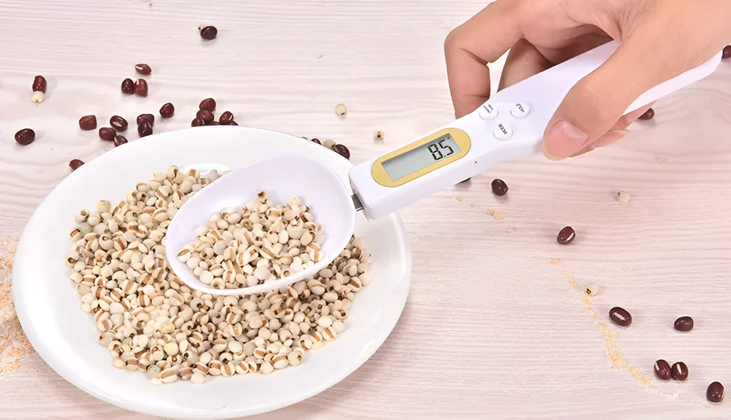 Black electronic measuring spoon scale with digital display on handle and integrated spoon bowl.