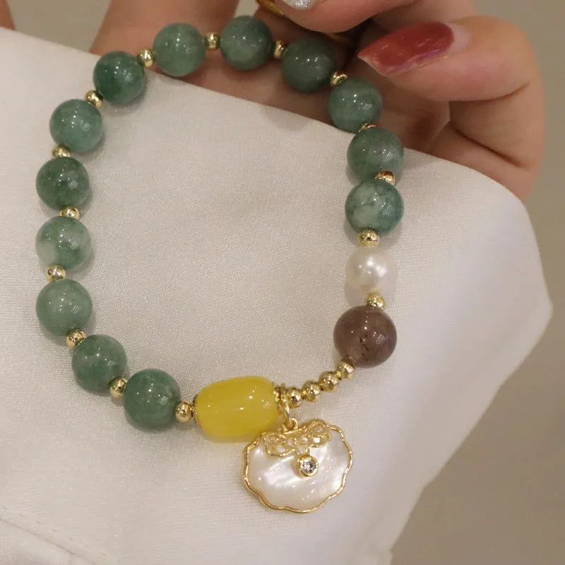 Green jade beaded bracelet with a silver-toned shell charm on an adjustable black cord.
