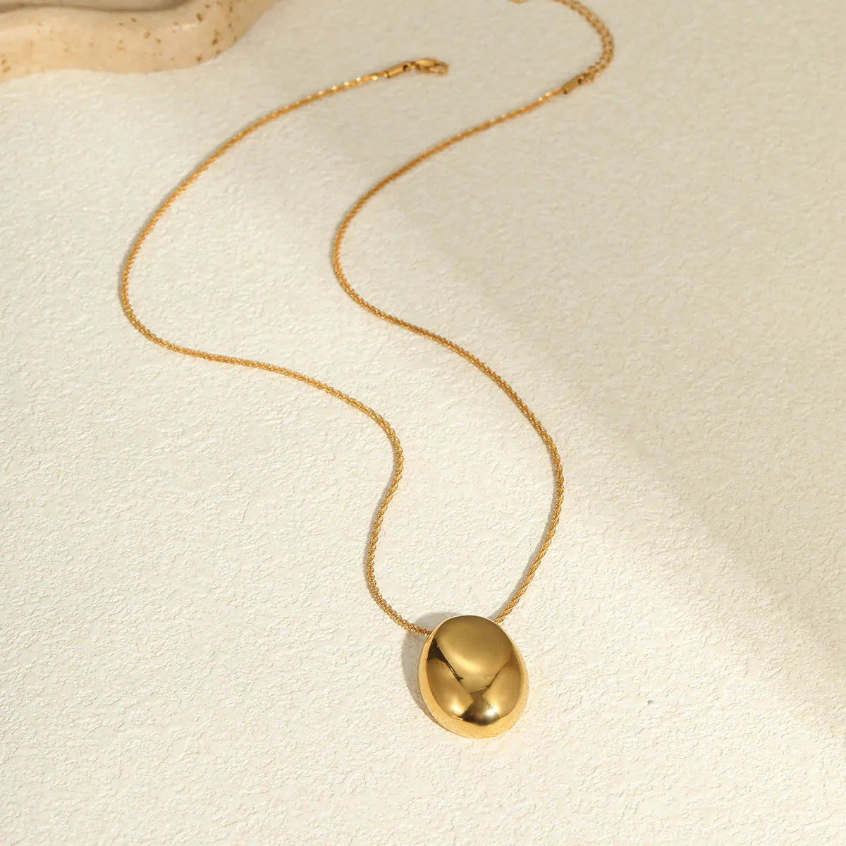 Gold-plated geometric necklace with stainless steel chain on display showing pendant detail
