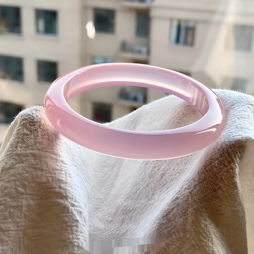 Natural agate wide tyre bracelet shown in multiple colour options on a wrist, demonstrating its substantial band width.