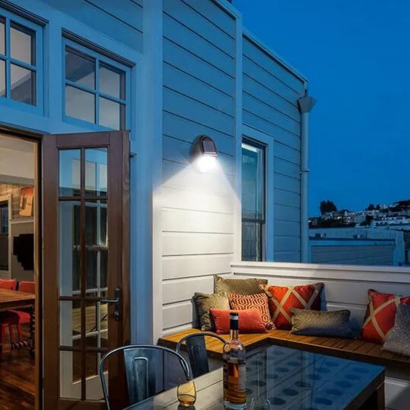 Black solar-powered LED wall light with motion sensor for outdoor security and garden lighting