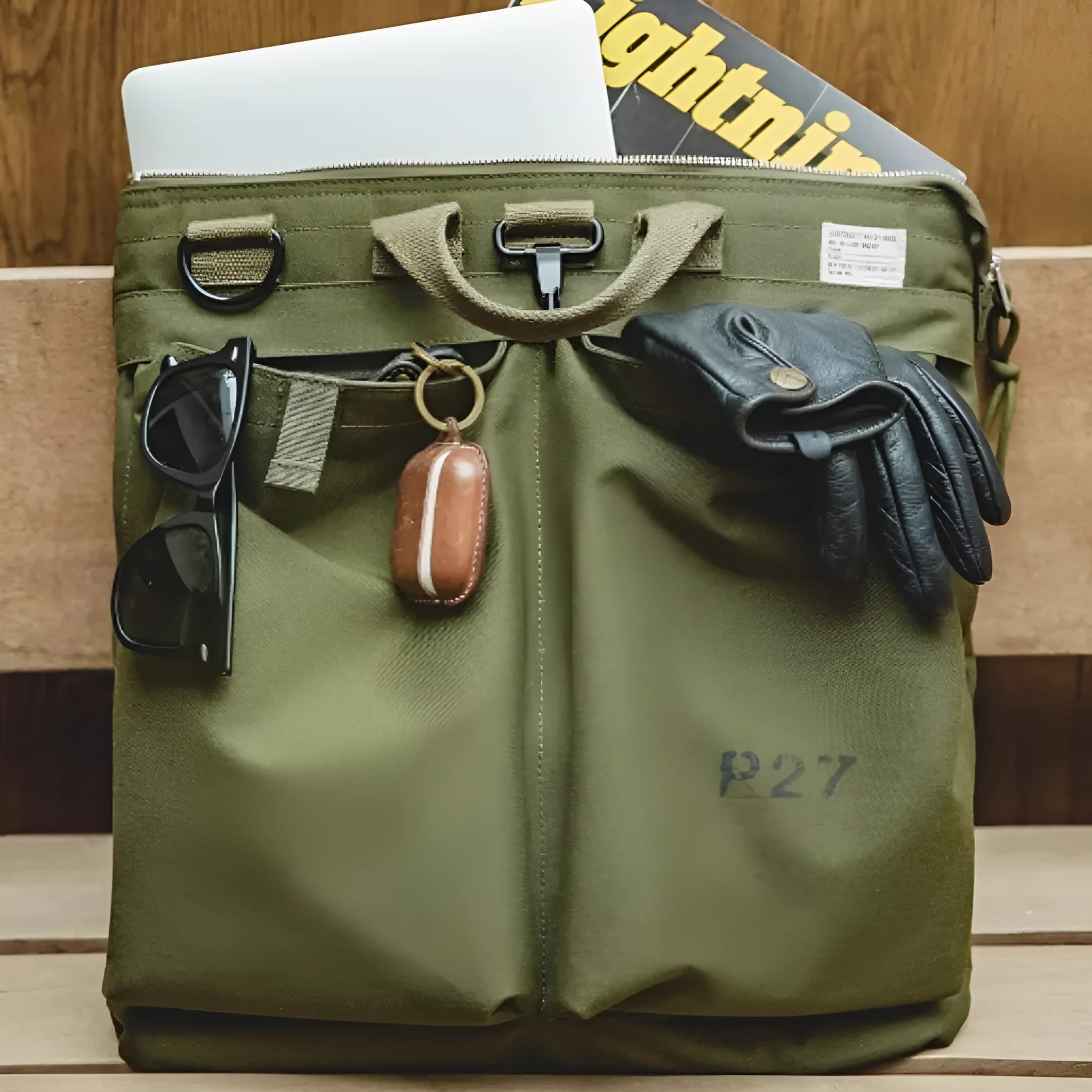 Military green canvas messenger bag with shoulder strap and zip closure showing internal phone pocket