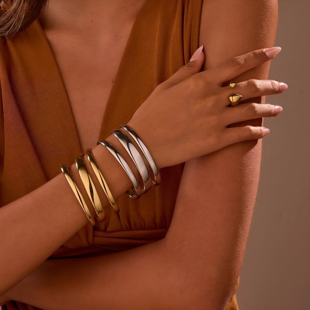 A geometric line design bracelet for women on wrist, shown in stainless steel with a simple opening clasp.