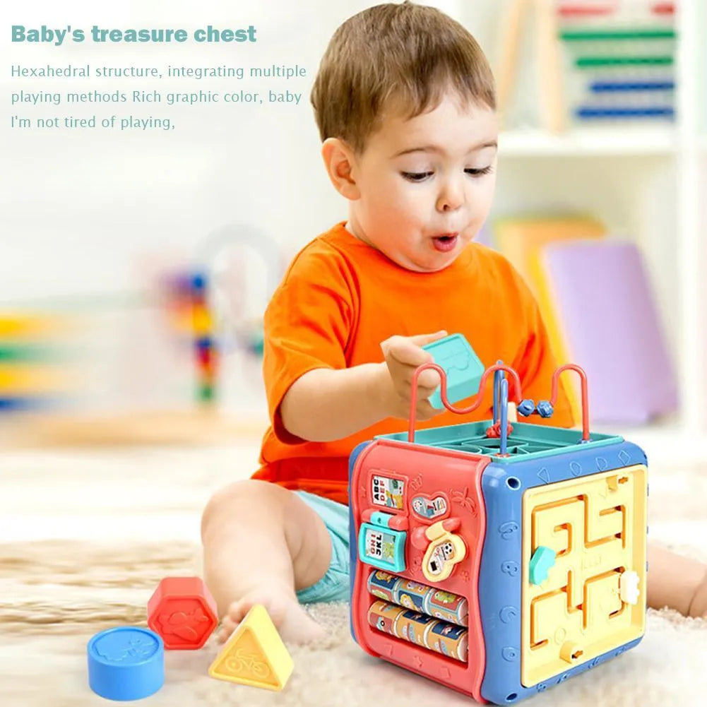 Colourful six-sided Montessori educational toy cube showing bead maze, gears, car track, clock, butterfly, and number activities