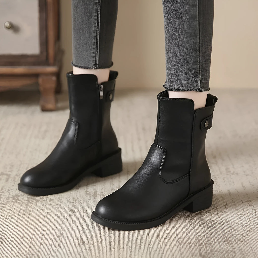 Black women's low heel ankle boots with a side zip and round toe on a rubber sole.