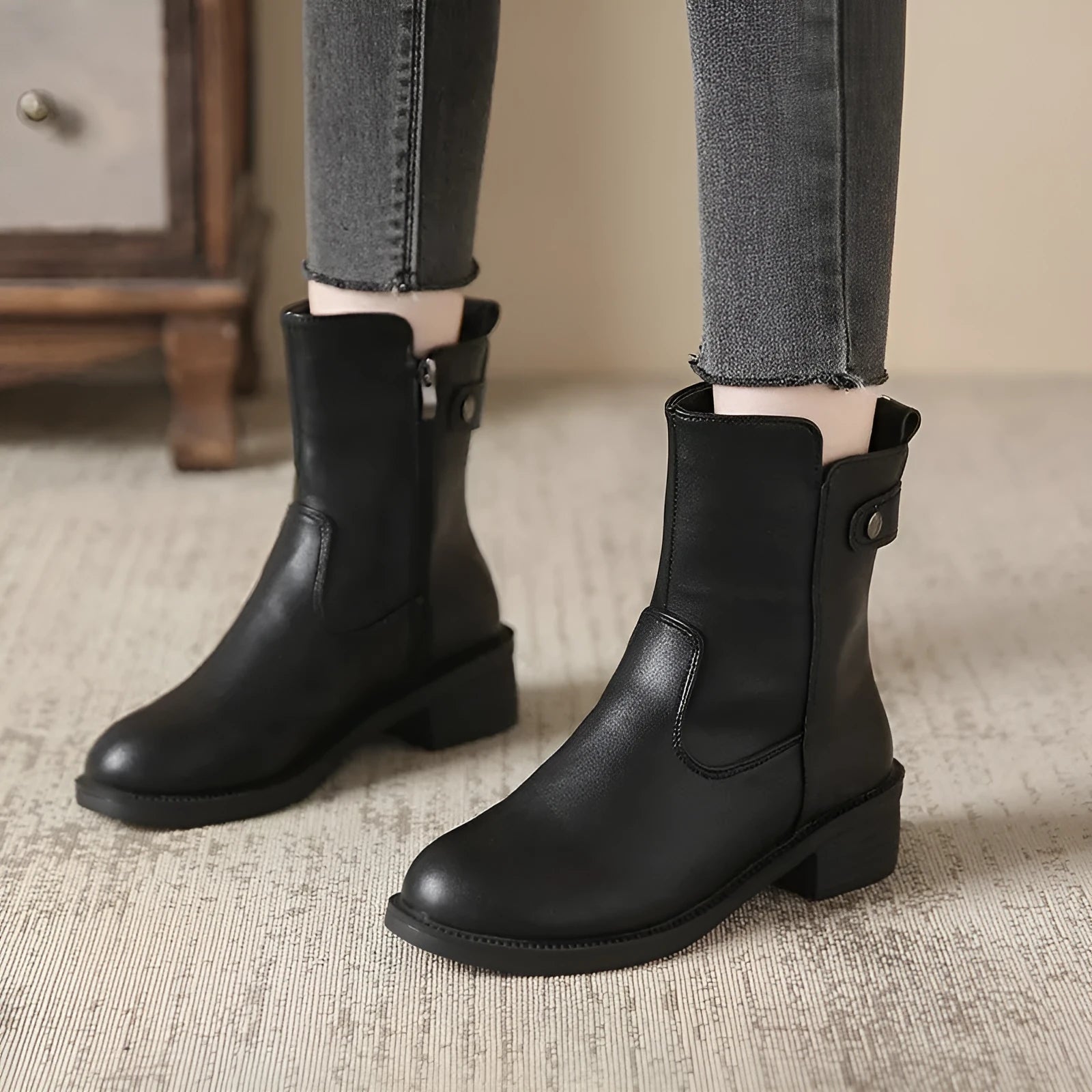 Black women's low heel ankle boots with a side zip and round toe on a rubber sole.