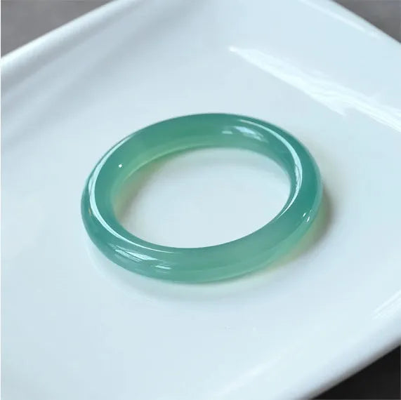Natural agate wide tyre bracelet shown in multiple colour options on a wrist, demonstrating its substantial band width.