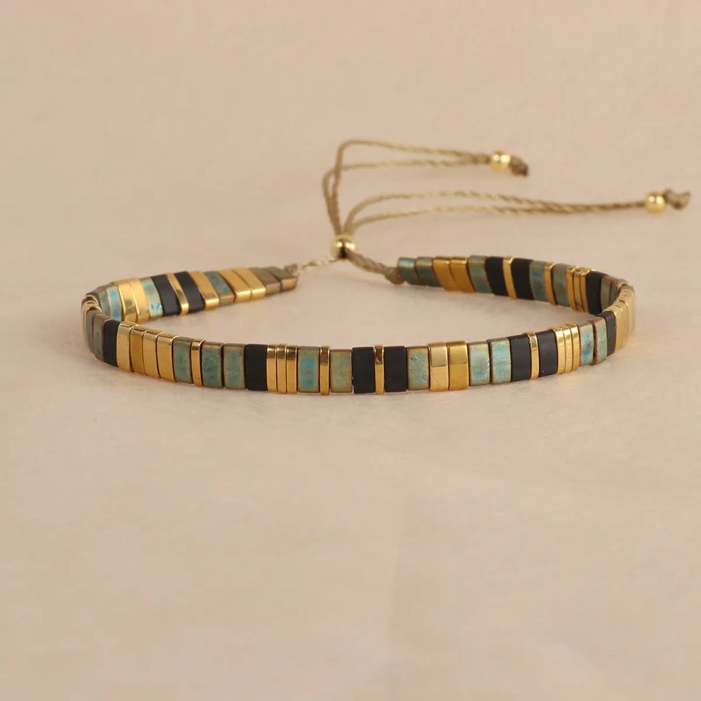 Geometric glass and coloured glaze beaded bracelet with a pull clasp in milky white colour.