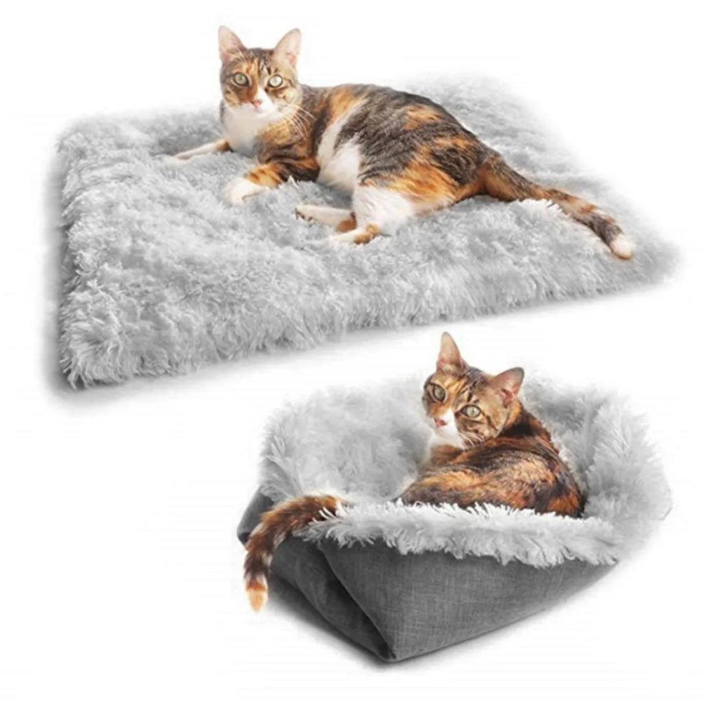 Grey plush pet blanket and bed with raised sides and a black non-slip bottom, shown on a wooden floor.