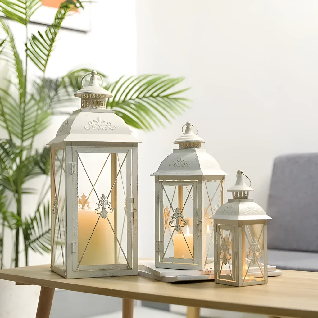 Black and white wrought iron floor-standing storm lantern with tempered glass panels in three sizes for courtyards.