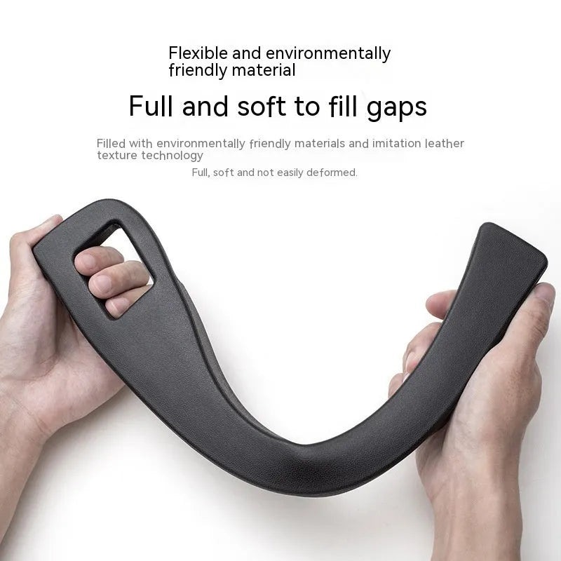 Black plastic car seat gap storage box with handle inserted between car seats.