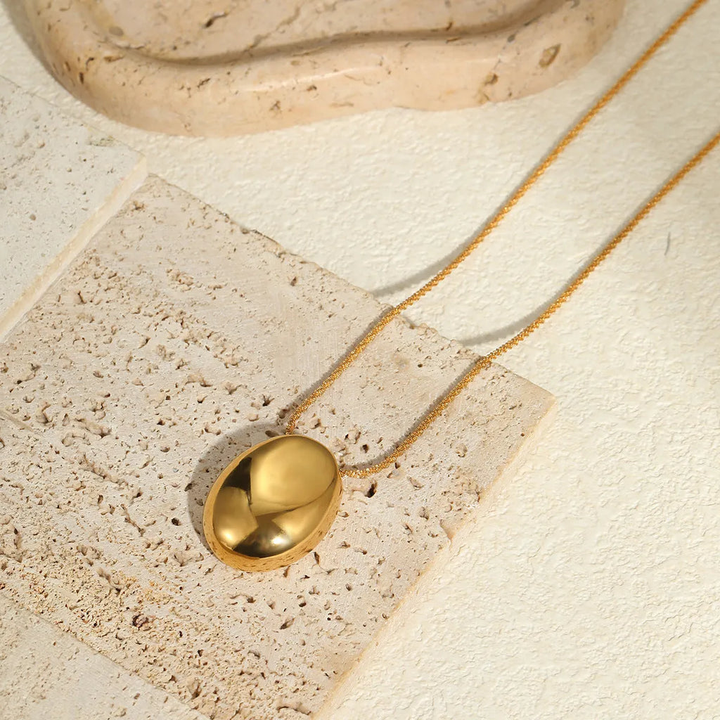 Gold-plated geometric necklace with stainless steel chain on display showing pendant detail