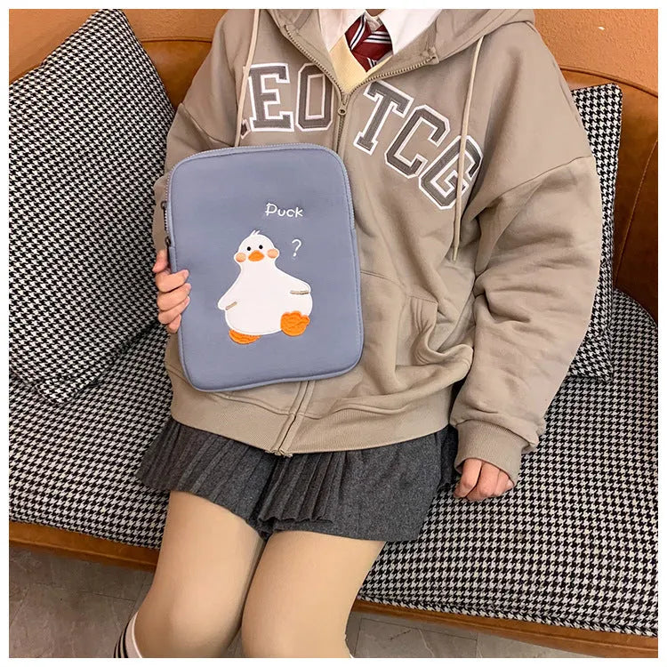 Blue cotton tablet case with embroidered cartoon duck design and a zipper, sized for an iPad.