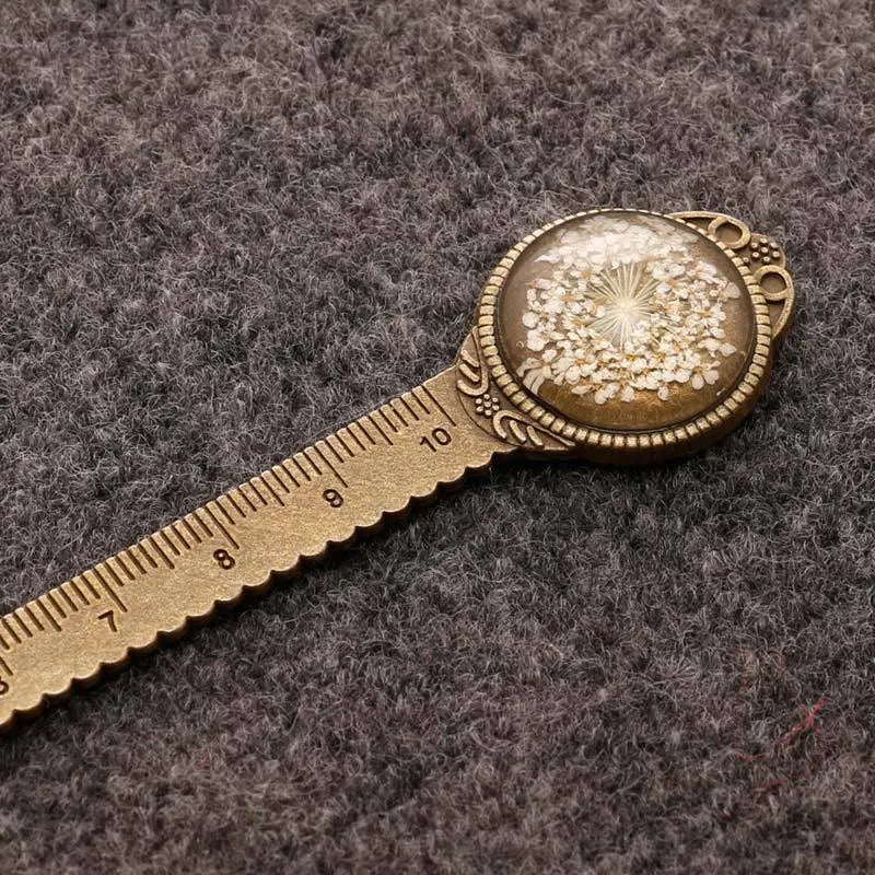 Handmade dried flower bookmark ruler with gypsophila, lace flowers, and clover, 12cm long on a book page.