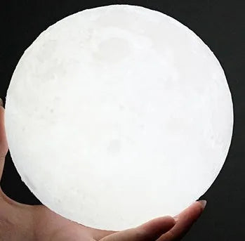 3D printed white moon lamp with detailed craters on a wooden stand, showing touch ring at base
