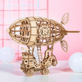 Four wooden 3D puzzle models showing an Airship, Balloon, Radio, and Pumpkin Carriage
