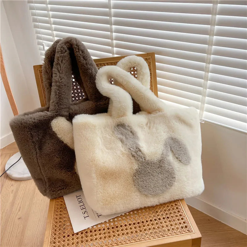 Plush shoulder bag with cartoon rabbit ears design in a solid colour.