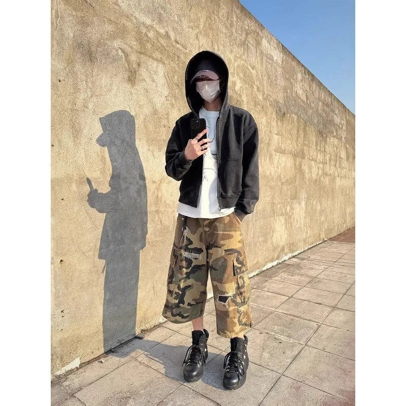 Men's loose camouflage cropped jeans with ripped knees and retro patch detailing on a thin cotton fabric.