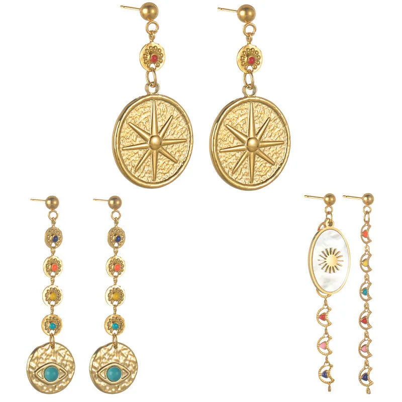 Geometric stainless steel drop earrings showing Eight Awn Star, Eye, and Shell Sun designs on a white background.