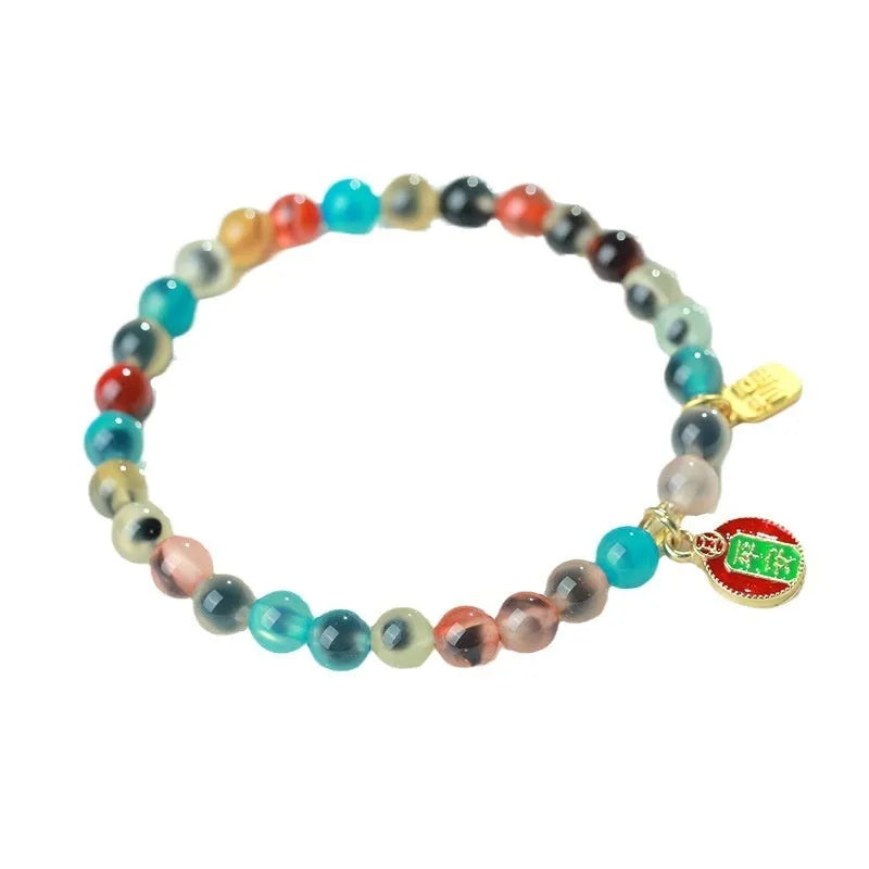Natural agate and coloured glaze snake bracelet with copper coin charms on a white background.