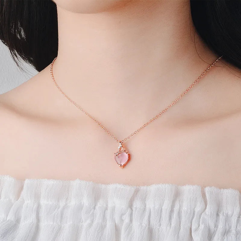 Rose gold women's necklace with a pink artificial crystal heart-shaped pendant on a cross chain