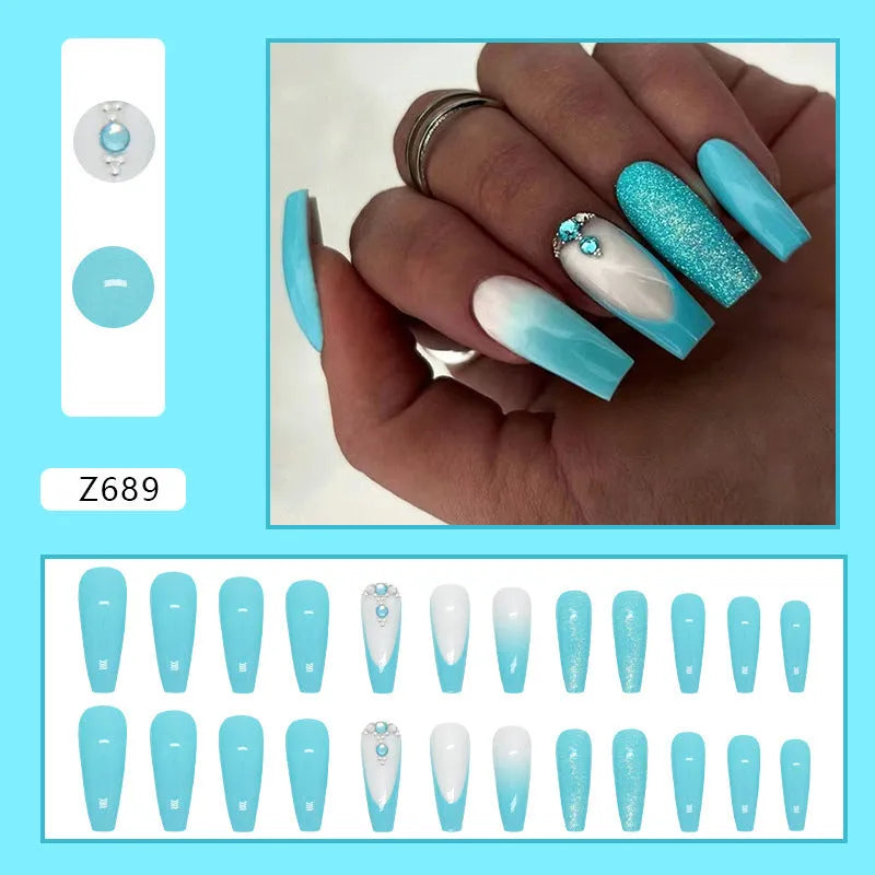 Long smart blue diamond false ballet nails with glitter particles and glue tube.