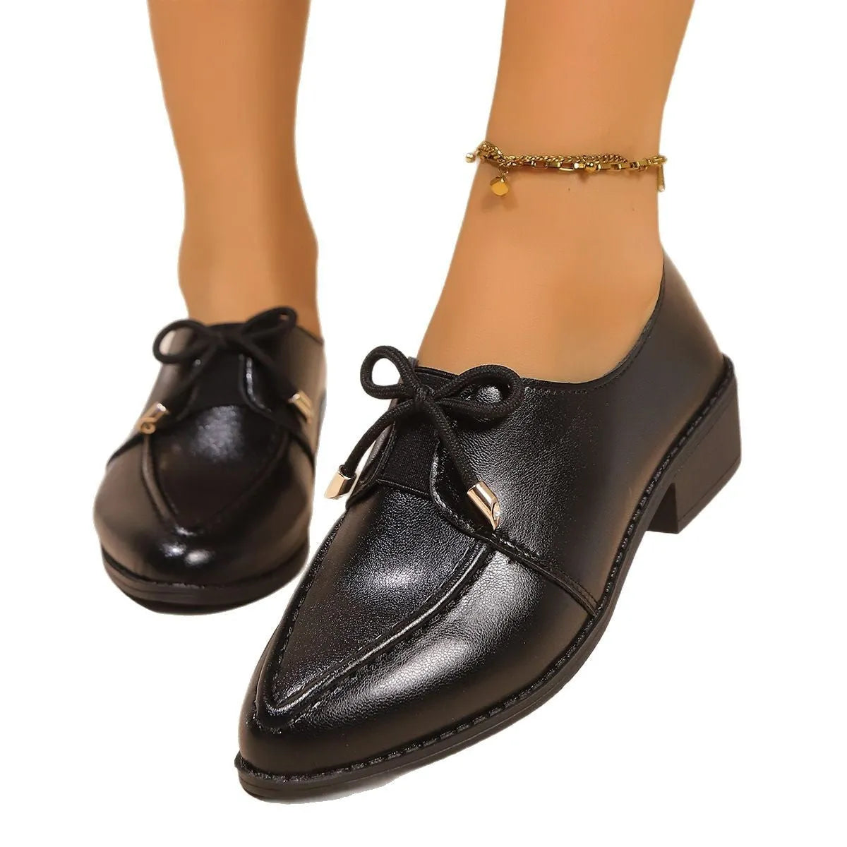 Women's British-style leather-look slip-on shoes with a decorative bow on the front