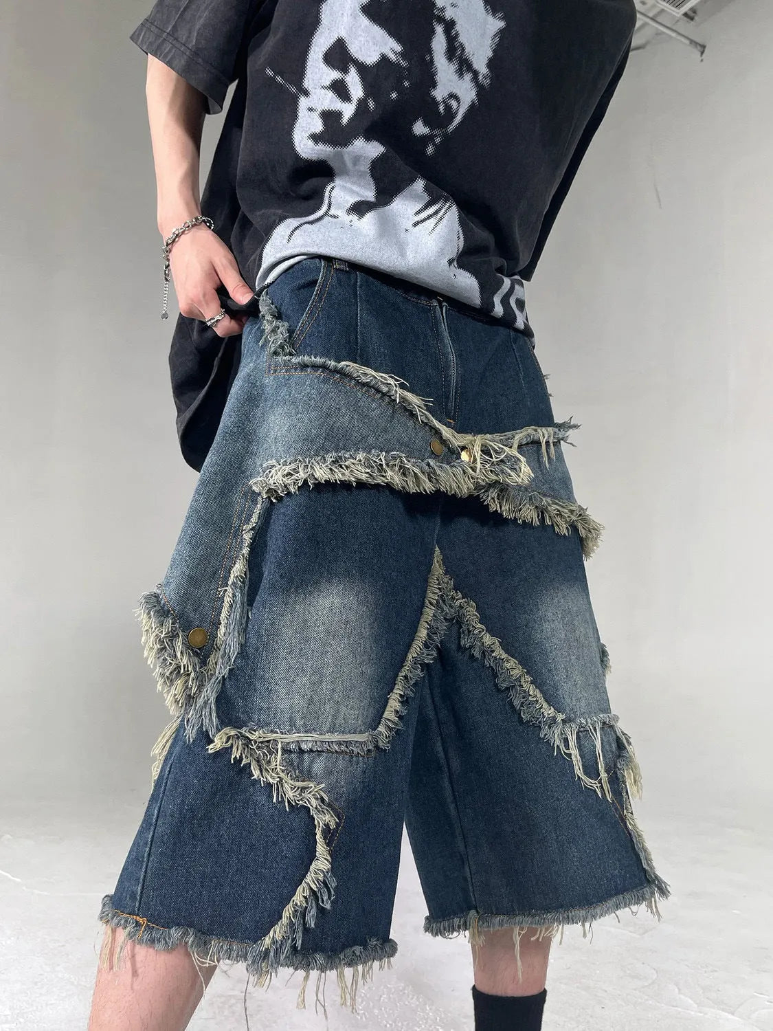 Blue American retro denim shorts with a frayed five-pointed star detail on the leg, shown in a loose fit.