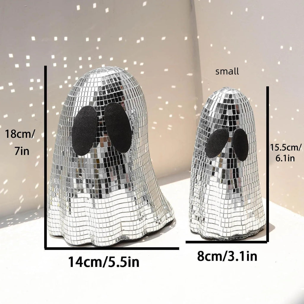 Silver glass Halloween ghost mosaic desktop decoration on a dark surface.