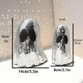 Silver glass Halloween ghost mosaic desktop decoration on a dark surface.
