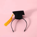 Yellow doctor's degree felt hair band and bow tie set on a small dog