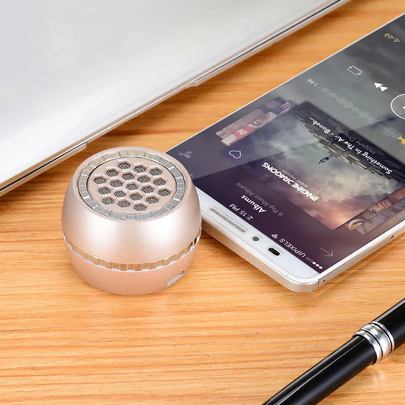 Black universal external amplifier speaker with a single channel, powered by a 5V mobile phone charger.