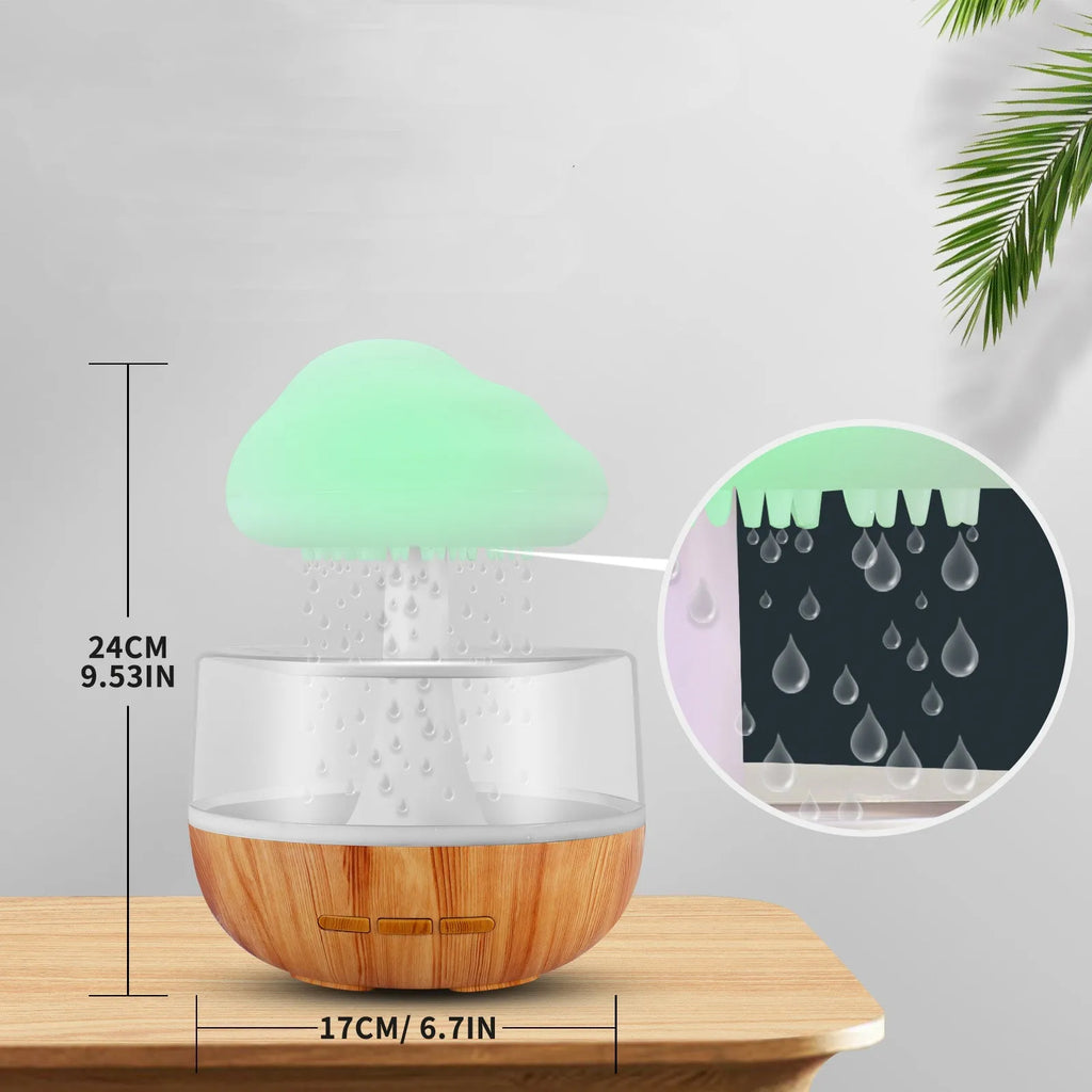 White cloud-shaped portable humidifier with coloured night light on a wooden table.