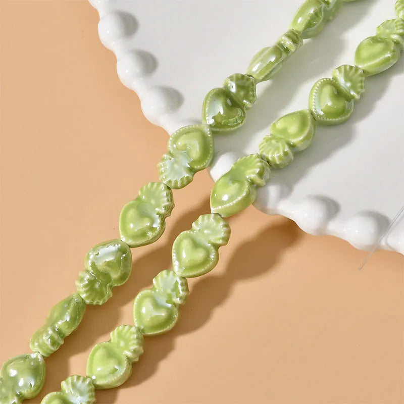 Ceramic love heart torch beads in multiple colours showing 10x15mm size and straight hole design