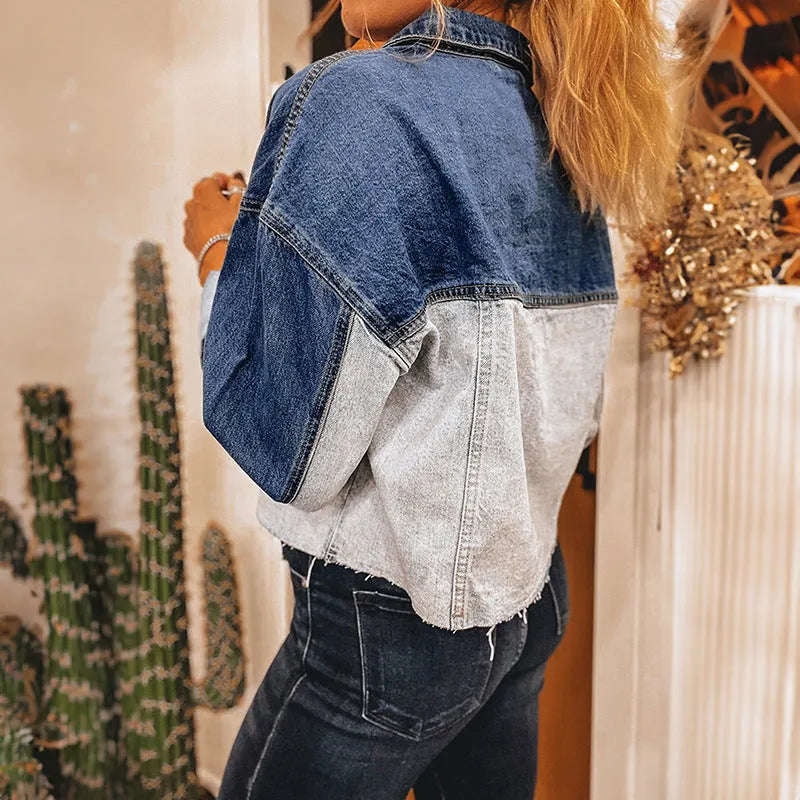 Women's loose blue denim coat with a row of silver buckle closures down the front.