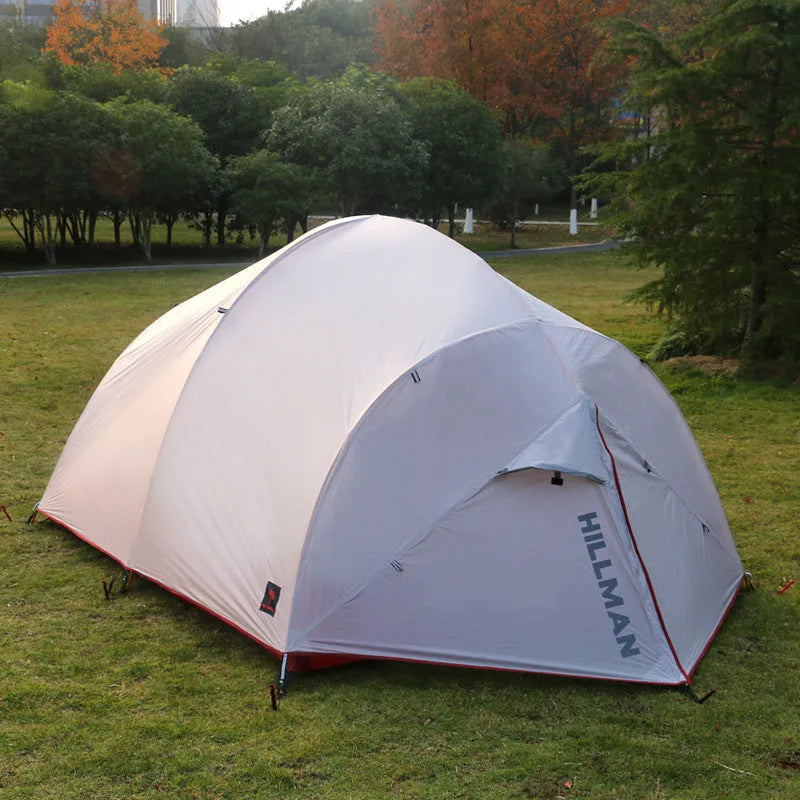 Grey outdoor multi-person tent with aluminum pole and nylon fabric set up on grass