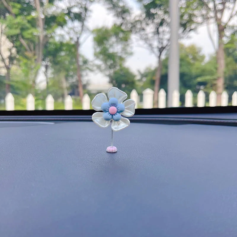 Small blue plastic swing-shaped car dashboard decoration.