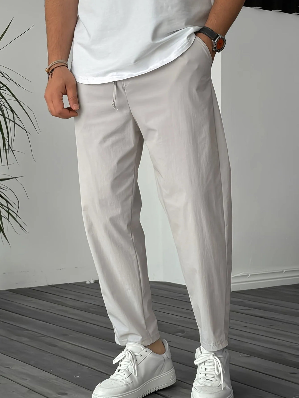 Men's khaki straight-leg casual trousers with a drawstring waist and a decorative ribbon pocket detail.