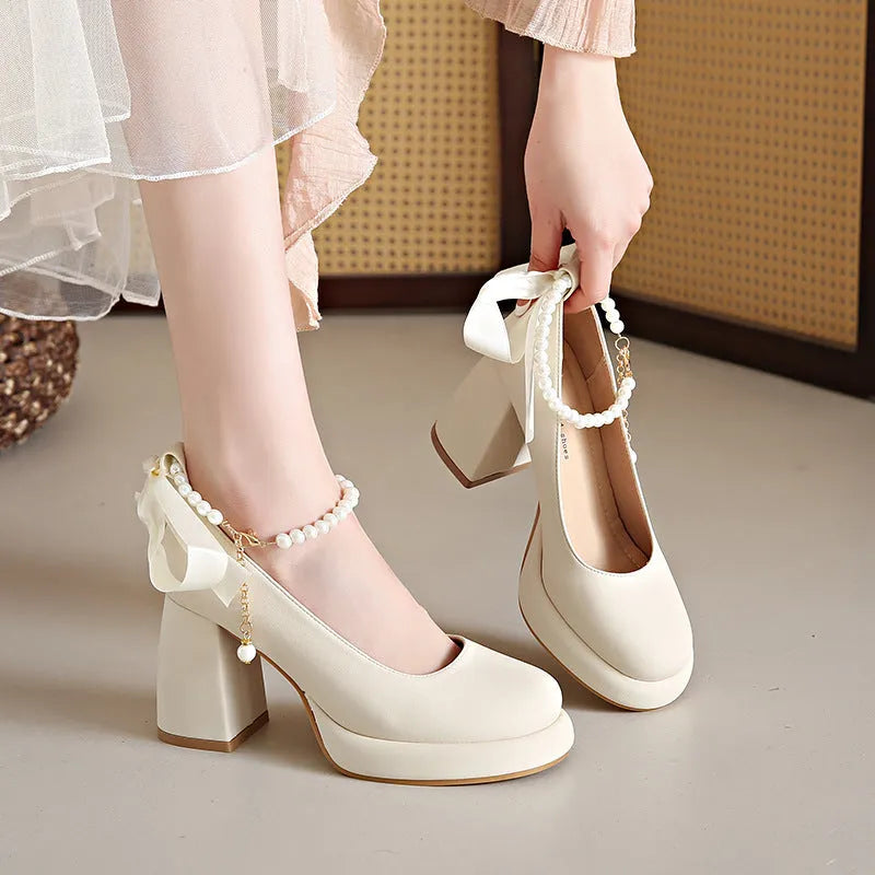 Women's beige Mary Jane shoes with ankle strap buckle, chunky low heel, pearl detail and round toe.